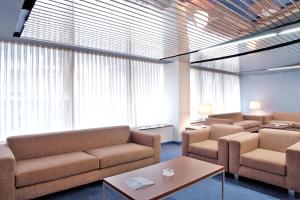 a waiting room with couches and tables and windows at Hotel Murrieta in Logroño
