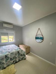 a bedroom with a bed and a mirror on the wall at Casa com banheira e lareira 12km da cidade in Santa Cruz do Sul