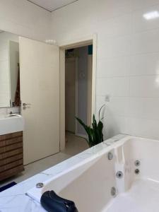 a white bathroom with a tub and a sink at Casa com banheira e lareira 12km da cidade in Santa Cruz do Sul +28 photos