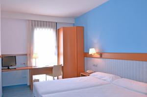a bedroom with a bed and a desk and a computer at Hotel Murrieta in Logroño