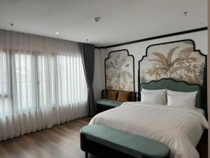 a bedroom with a large bed with a large headboard at Aquarius Premium Hotel in Hanoi