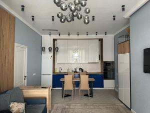 a living room with a table and a kitchen at Уютный коттедж "PARIS", 30м от пляжа! 3 спальни, терраса и летняя кухня! in Chok-Tal