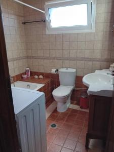 W łazience znajduje się toaleta, wanna i umywalka. w obiekcie Rikas w mieście Porto Heli
