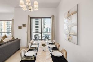 a dining room with a table and a couch at Sunkissed holiday homes 2-3BR Apartments on JBR beach near mall & metro & bluewaters Island in Dubai
