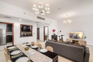 sala de estar con mesa y sofá en Sunkissed holiday homes 2-3BR Apartments on JBR beach near mall & metro & bluewaters Island, en Dubái