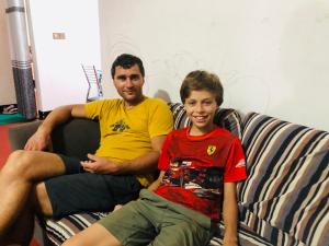 un hombre y un niño sentado en un sofá en R & D Resort en Polonnaruwa