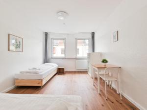 - une chambre avec un lit, une table et deux fenêtres dans l'établissement RAJ Living - 4 Zimmer Wohnung - 25 Min zur Messe DUS, à Krefeld