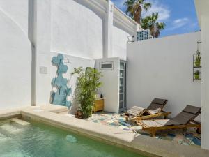a house with a swimming pool and two chairs at Quinta Lolita - La Paz Baja California Sur in La Paz