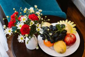 two white plates with flowers and fruit on a table at A&D Luxury Hotel in Hanoi