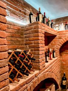 a brick wall with a bunch of wine bottles at Central Hotel Kutaisi in Kutaisi