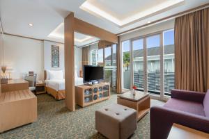 Habitación de hotel con cama y TV en Swiss-Belhotel Danum Palangkaraya en Palangkaraya