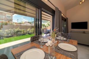 イラクリトサにあるAnalemma Luxury Villasのテーブルと大きな窓のあるダイニングルーム