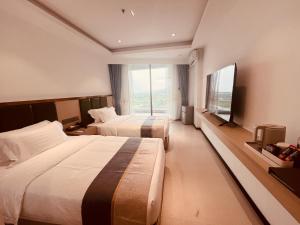 a hotel room with two beds and a flat screen tv at Platinum Coast Hotel and condominium 