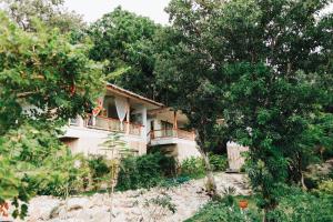 a house on a hill with trees in front of it at Siam Cookies Cottage in Haad Pleayleam