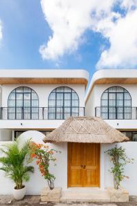 a white building with a thatch roof at New Designer 2BR Villa in Canggu in Canggu
