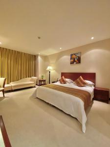duża sypialnia z dużym łóżkiem i kanapą w obiekcie Beijing Palace Soluxe Hotel Astana w mieście Astana