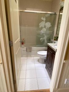 Un baño con bañera, inodoro y lavabo. en Victory House, en Burnaby
