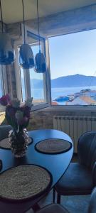 uma mesa azul com um vaso de flores em Apartments Ita - Postira em Postira