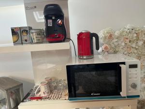 eine Mikrowelle im Regal mit Kaffeemaschine in der Unterkunft Chez Régine, ETAGE privé, 45M2 in Schiltigheim