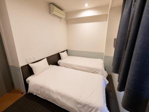 Postel nebo postele na pokoji v ubytování Hotel Taiyo Noen Tokushima Kenchomae