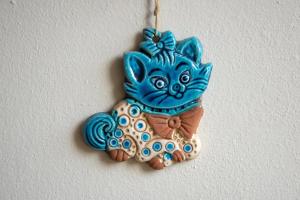 a blue cat ornament hanging on a wall at Estrella Studios in Chania Town