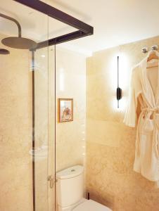 a bathroom with a toilet and a glass shower stall at Fridda House Atocha Madrid in Madrid