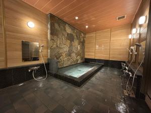 a large bathroom with a tub with a shower at Matsumoto Ryokan in Kyoto +49 photos