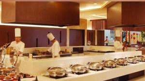 un grupo de chefs en una cocina preparando comida en HOTEL AIRPORT PALACE, en Nueva Delhi