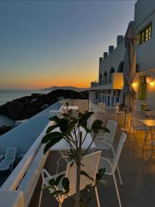 a balcony with a table and chairs and the ocean at Hotel Petradi in Ios Chora