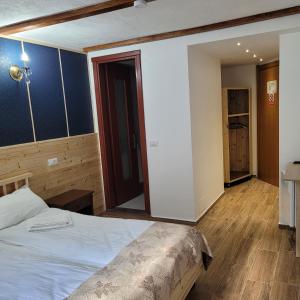 een slaapkamer met een bed in een kamer met houten vloeren bij Natura Tusnad in Băile Tuşnad