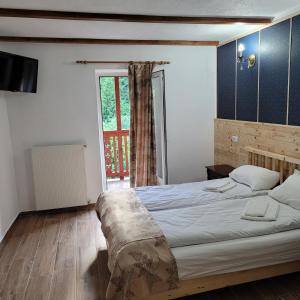Un dormitorio con una cama grande y una ventana en Natura Tusnad en Băile Tuşnad