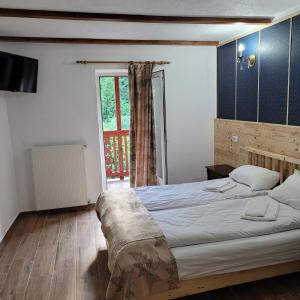a bedroom with a large bed and a window at Natura Tusnad in Băile Tuşnad +43 photos