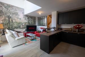 uma cozinha com armários pretos e uma sala de estar em DUPLEX Luxury-Appart - DYSNEY LAND PARIS em Bussy-Saint-Georges