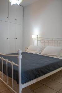 a bedroom with a white bed with a blue blanket at Mamouth Studios in Chania Town