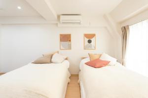 two white beds in a room with a window at Residence Stay Hanzomon - レジデンススティ半蔵門 in Tokyo