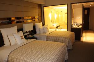 a hotel room with two beds and a bathroom at Four Points By Sheraton Beijing, Haidian in Beijing