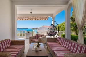 eine Terrasse mit Sofas und einem Tisch sowie Meerblick in der Unterkunft Villa Gajeta in Sevid