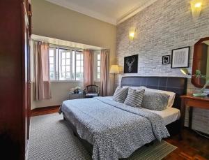 een slaapkamer met een bed en een bakstenen muur bij Green Hill Tanah Rata Cameron Highland in Tanah Rata