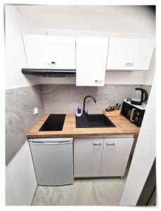 a kitchen with white cabinets and a sink at SouvenirAppart Sniadeckich in Bydgoszcz +13 photos