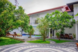 a courtyard of a house with trees and benches at Loony Villa in Negombo