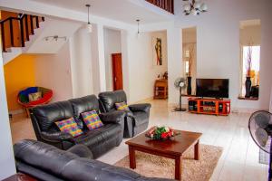 a living room with a leather couch and a table at Loony Villa in Negombo