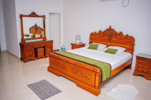 a bedroom with a large wooden bed and a mirror at Loony Villa in Negombo +11 photos