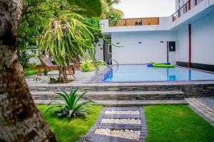a swimming pool in a yard with a house at Loony Villa in Negombo