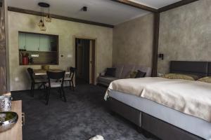 1 dormitorio con cama, mesa y sofá en Luxusní apartmán Domovjanka - MEDVĚDÍN en Bílá