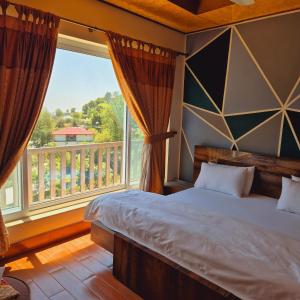 a bedroom with a bed and a large window at Roof Top Resort in Murree