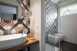 a bathroom with a sink and a mirror at Marina Garden Hotel in Marciana Marina