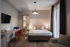 - une chambre avec un lit, un bureau et un canapé dans l'établissement Marina Garden Hotel, à Marciana Marina