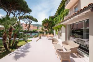 einen Balkon mit Stühlen und Tischen auf einem Gebäude in der Unterkunft Marina Garden Hotel in Marciana Marina