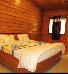 a bedroom with a bed in a log cabin at Royalstar Resort in Vagator