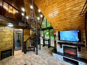 a living room with a fireplace and a flat screen tv at Cabana Zimbru Transfagarasan in Arefu